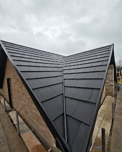 Modern slate-grey roof with sharp V-valley detailing installed by JP Bobcat Roofing in Warwickshire