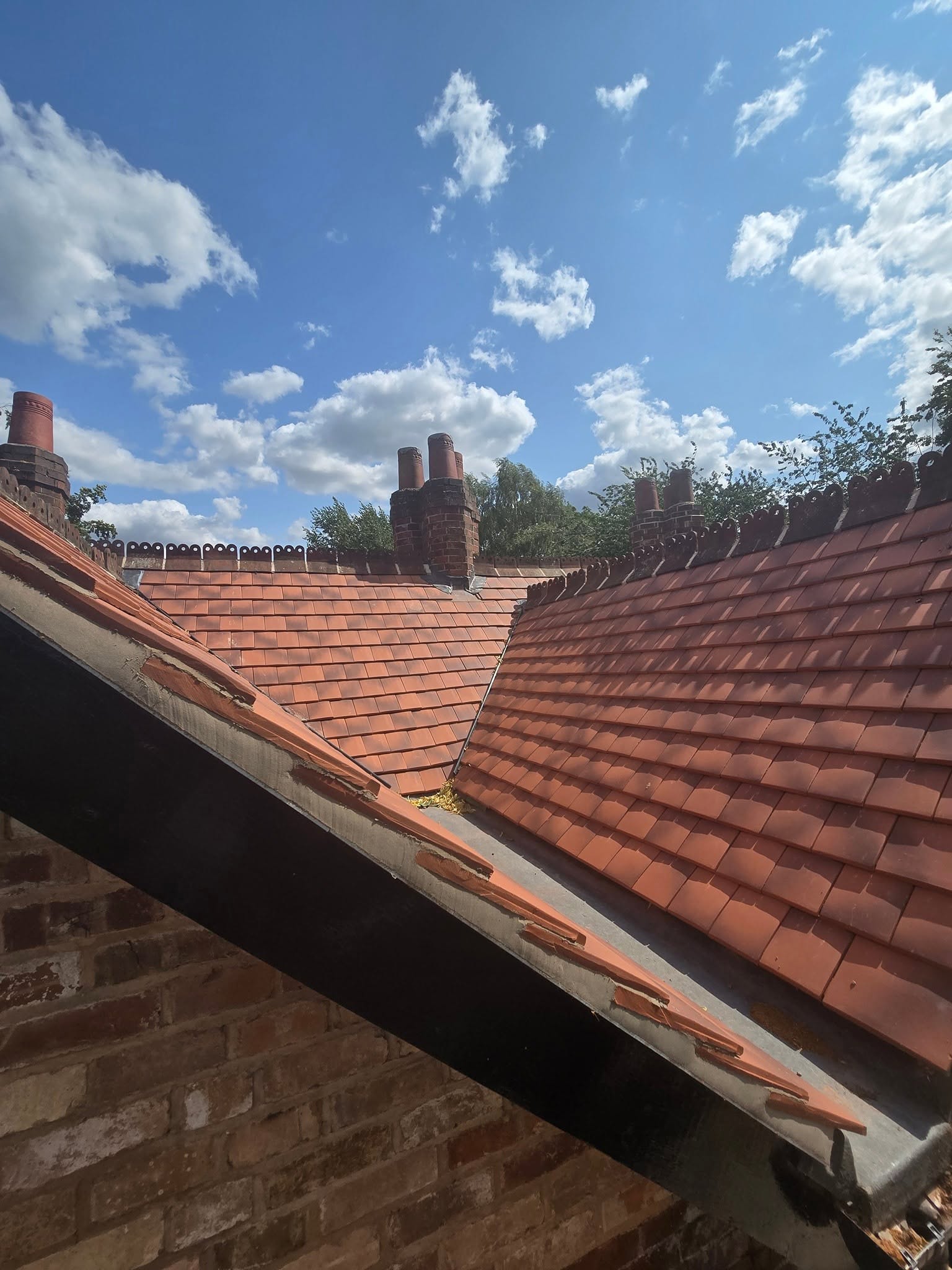 Close-up of newly laid clay plain tiles and ridge line by JP Bobcat Roofing, Warwickshire roofers