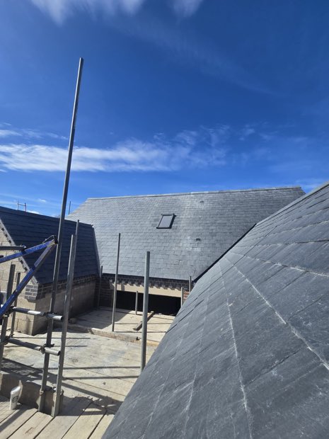 Spanish slate hips and valleys being set out on a new-build bungalow in Barby