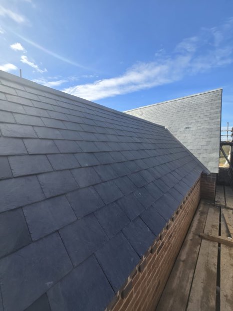 Even courses of Spanish slate from eaves to ridge on a new-build roof in Barby