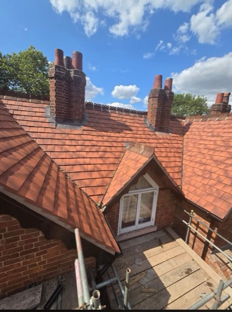 New roof tiles and lead flashings around brick chimney stacks on a period house in Uttoxeter