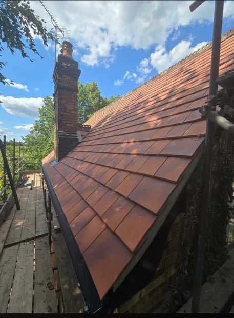 New roof tiling brought to a brick chimney stack on a low-pitch elevation in Uttoxeter